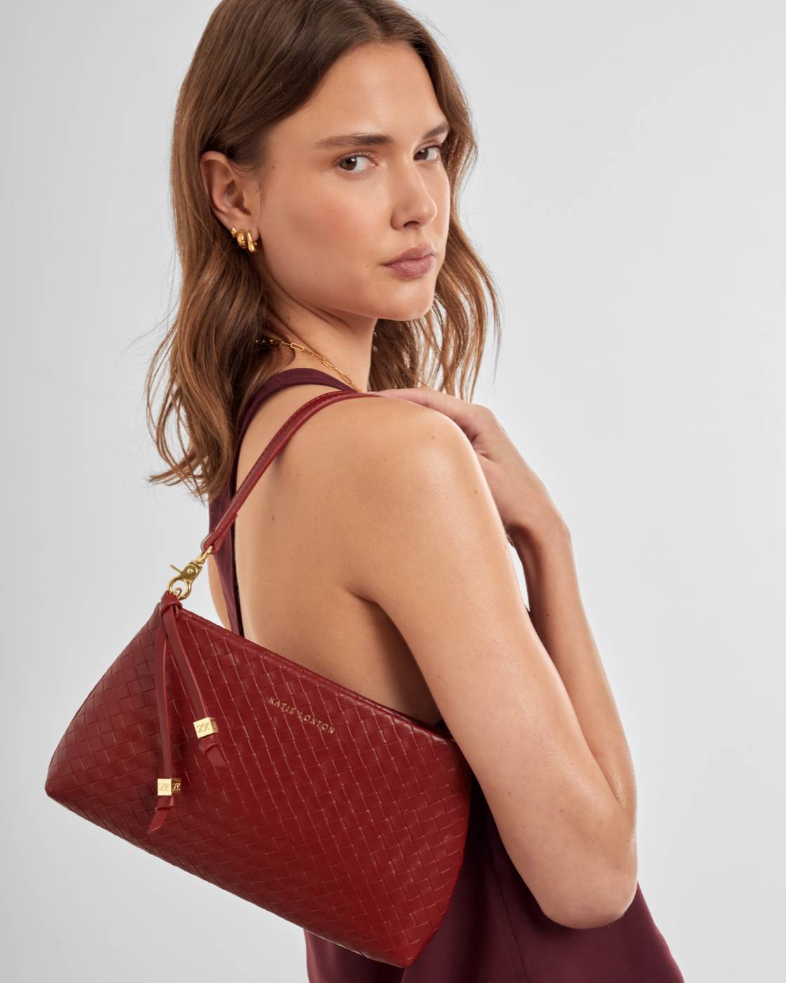 Nova small shoulder bag in crimson woven vegan leather with charm tassel