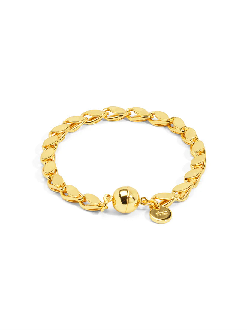 Gold chain bracelet with a heart charm on a white background