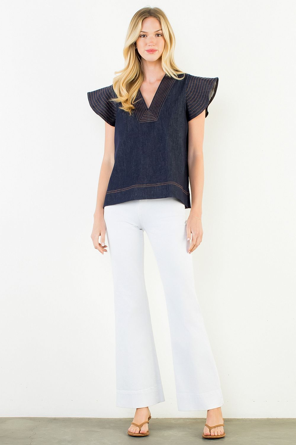 Midnight denim flutter sleeve top with contrast stitching